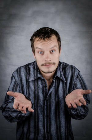 A man shrugging and presenting both of his hands forward, to illustrate the idea of simply asking something