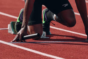 A runner ready to start a race with a baton in hand, representing InDev’s readiness to help emerging market based asset managers to source large-scale global investors.