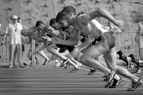 A number of runners take off from starting blocks at the beginning of a race